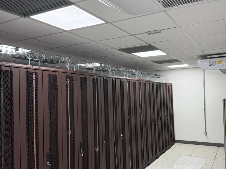 Sala de racks do datacenter RNP/PoP-BA, com infraestrutura de cabeamento e climatização.